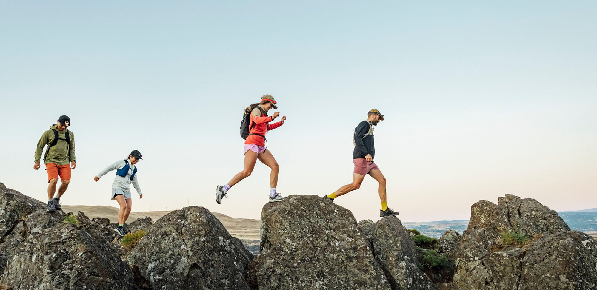 a group of hikers moves fast across a boulder field